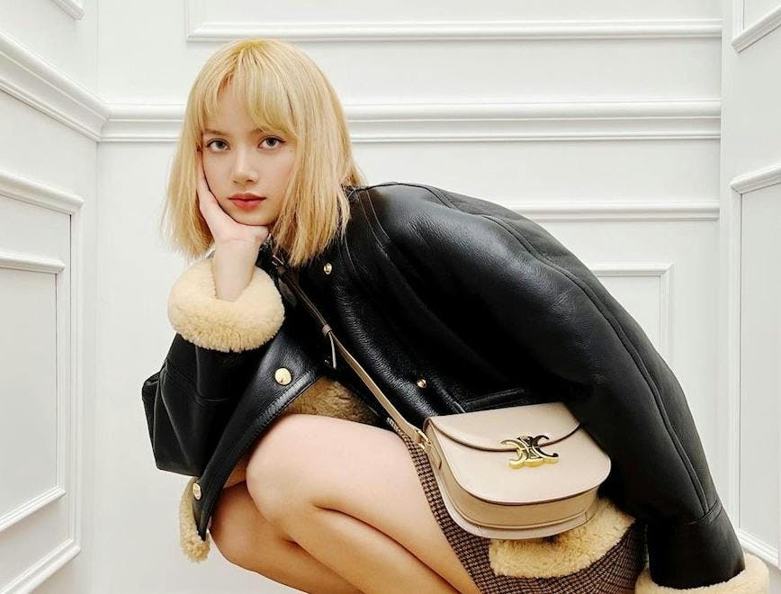 sitting person handbag bag accessories blonde shoe footwear jacket coat