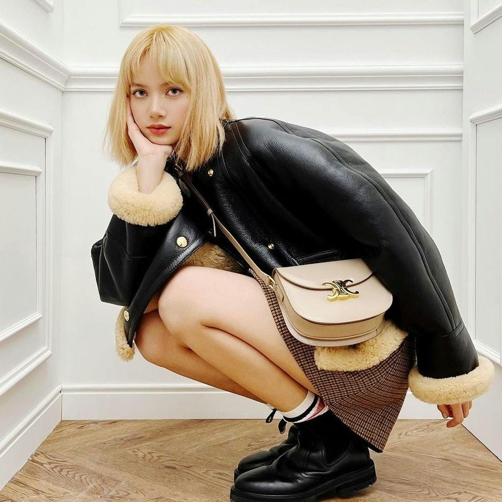 sitting person handbag bag accessories blonde shoe footwear jacket coat